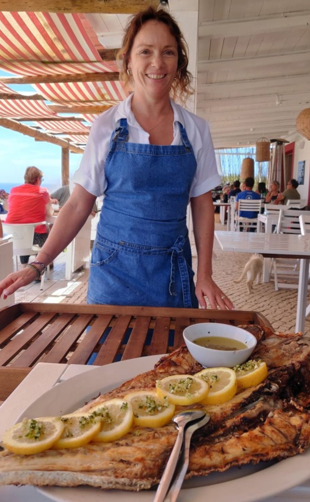 Smiling chef standing over grilled fish