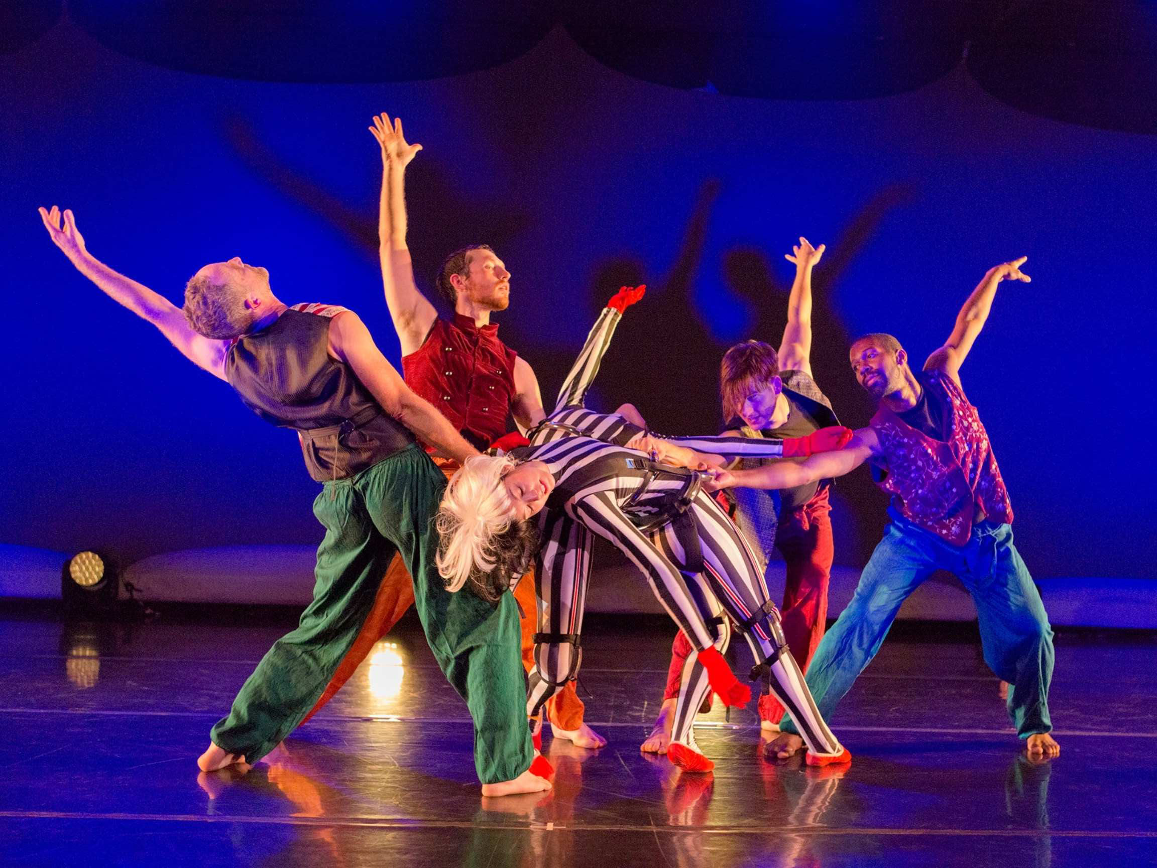 Group of male dancers catch falling female dancers on stage