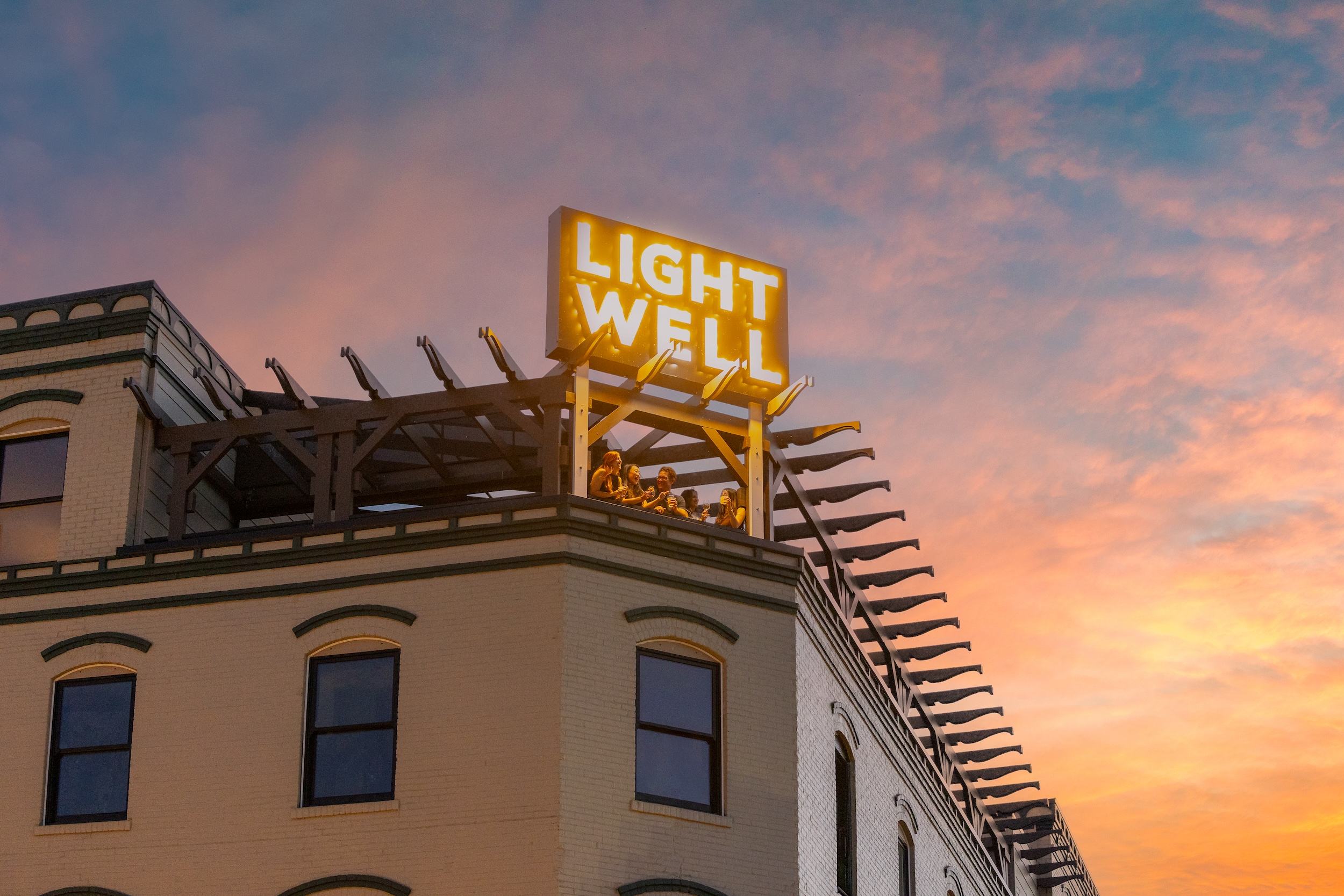 Roof of historic brick building with lit sign with lettering for Lightwell