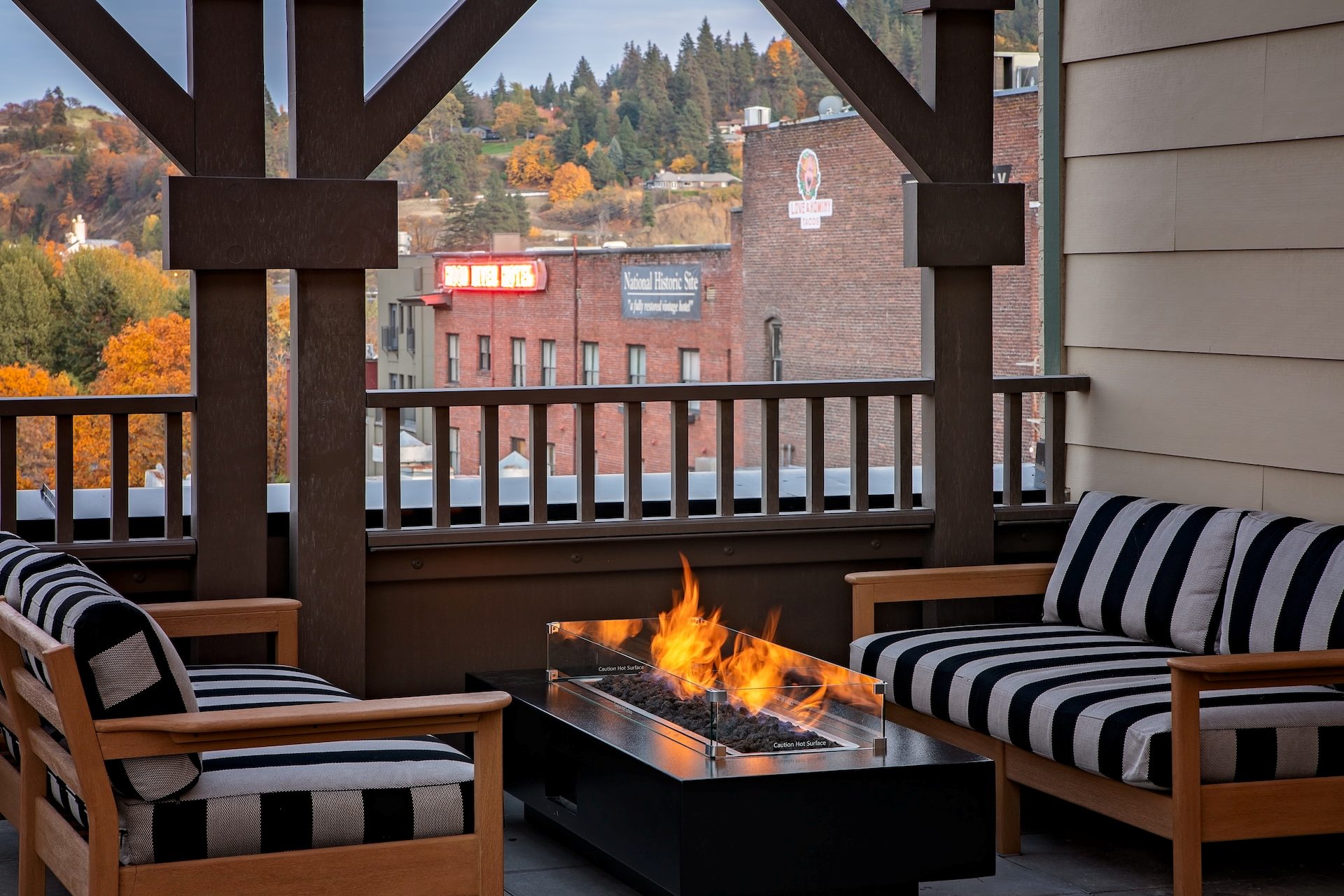 Rooftop patio with firepit and view of historic brick buildings