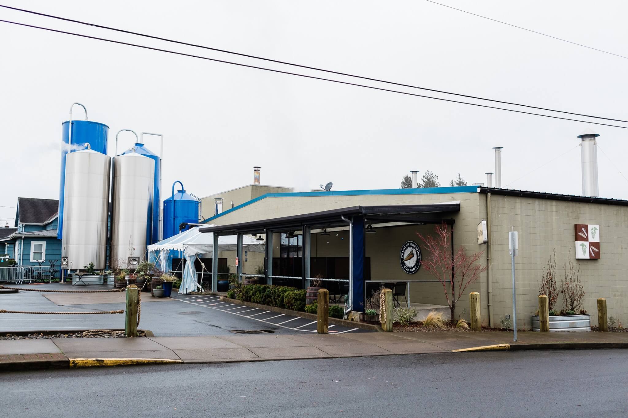 Outside view of the taproom. Five large tanks sit outside, part of the brewing process.