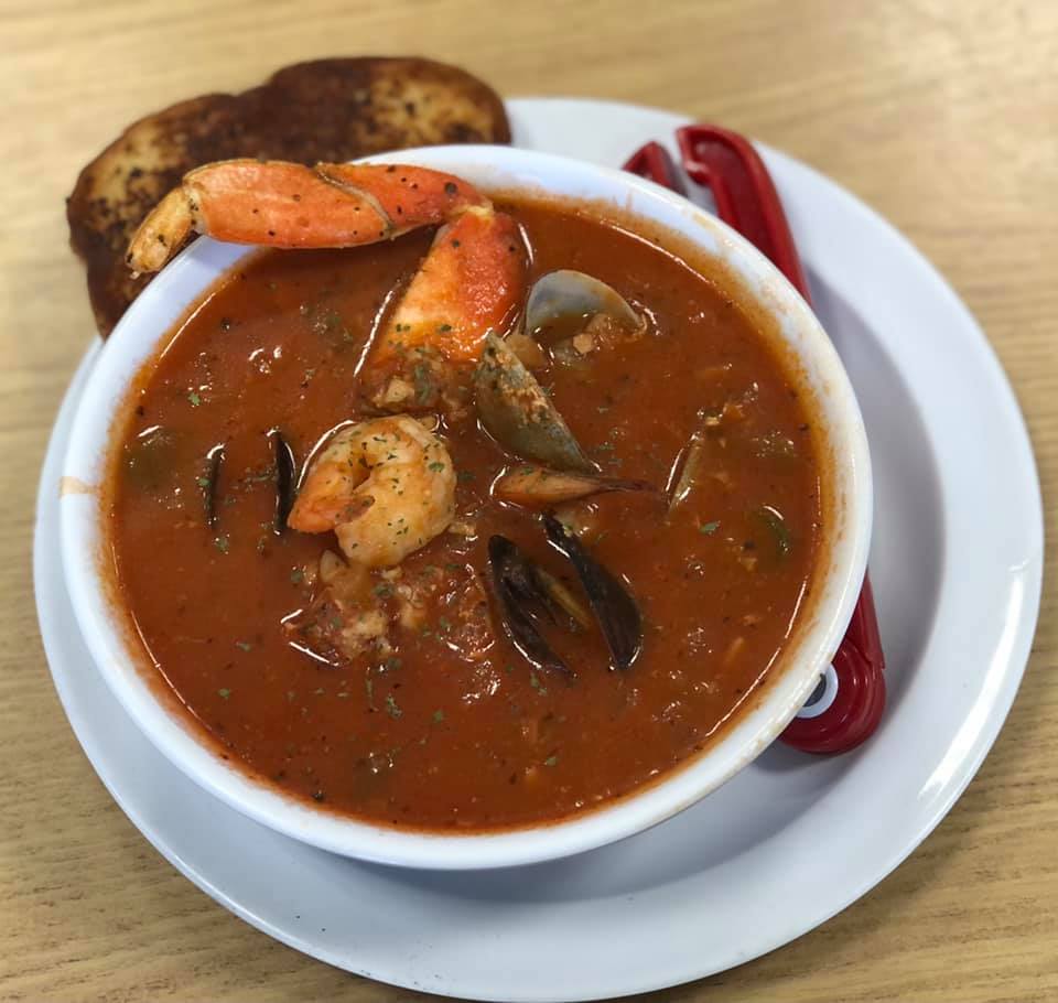 Bowl of cioppino with clams, crab, and shrimp
