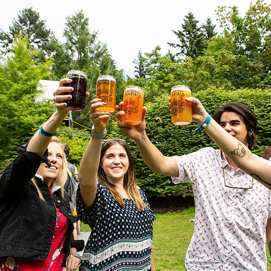 Group of people raise beer glasses