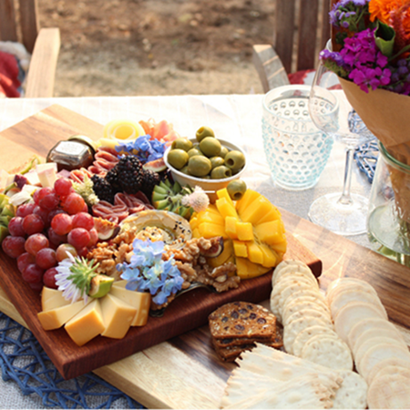 Charcuterie board with grapes, meat, cheeses, bread and crackers
