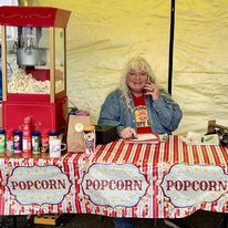 Popcorn booth with yellow background and woman on the phone.