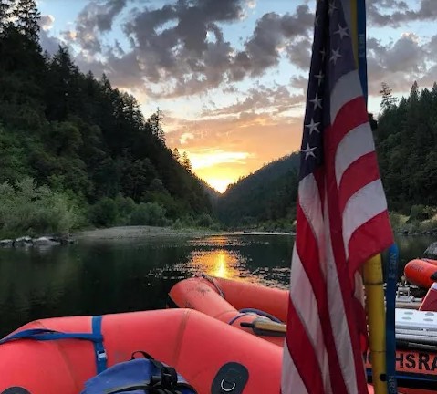 Sunset over river with american flag