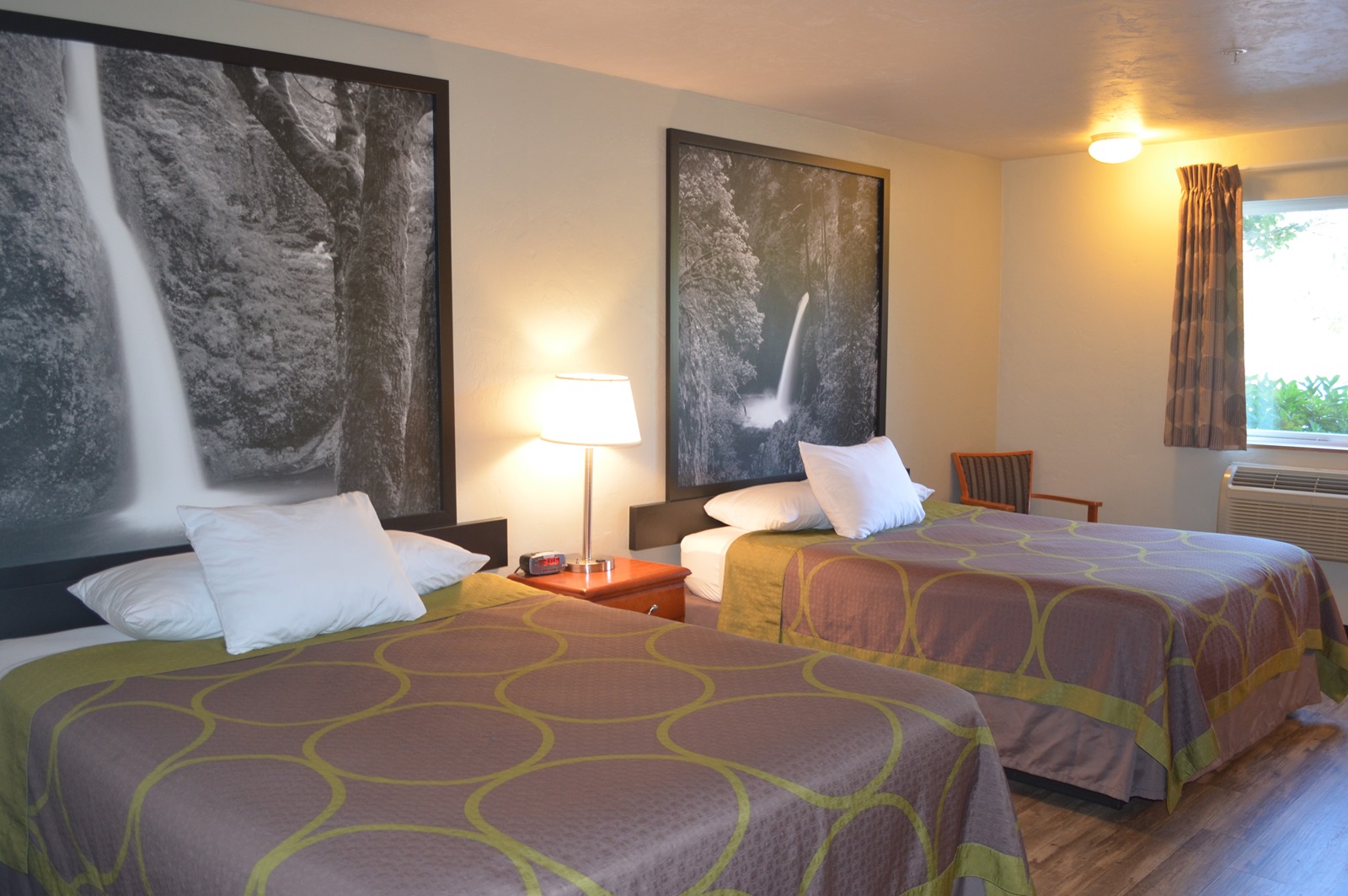 Bedroom with 2 queen sized beds and pictures of falls on the wall.