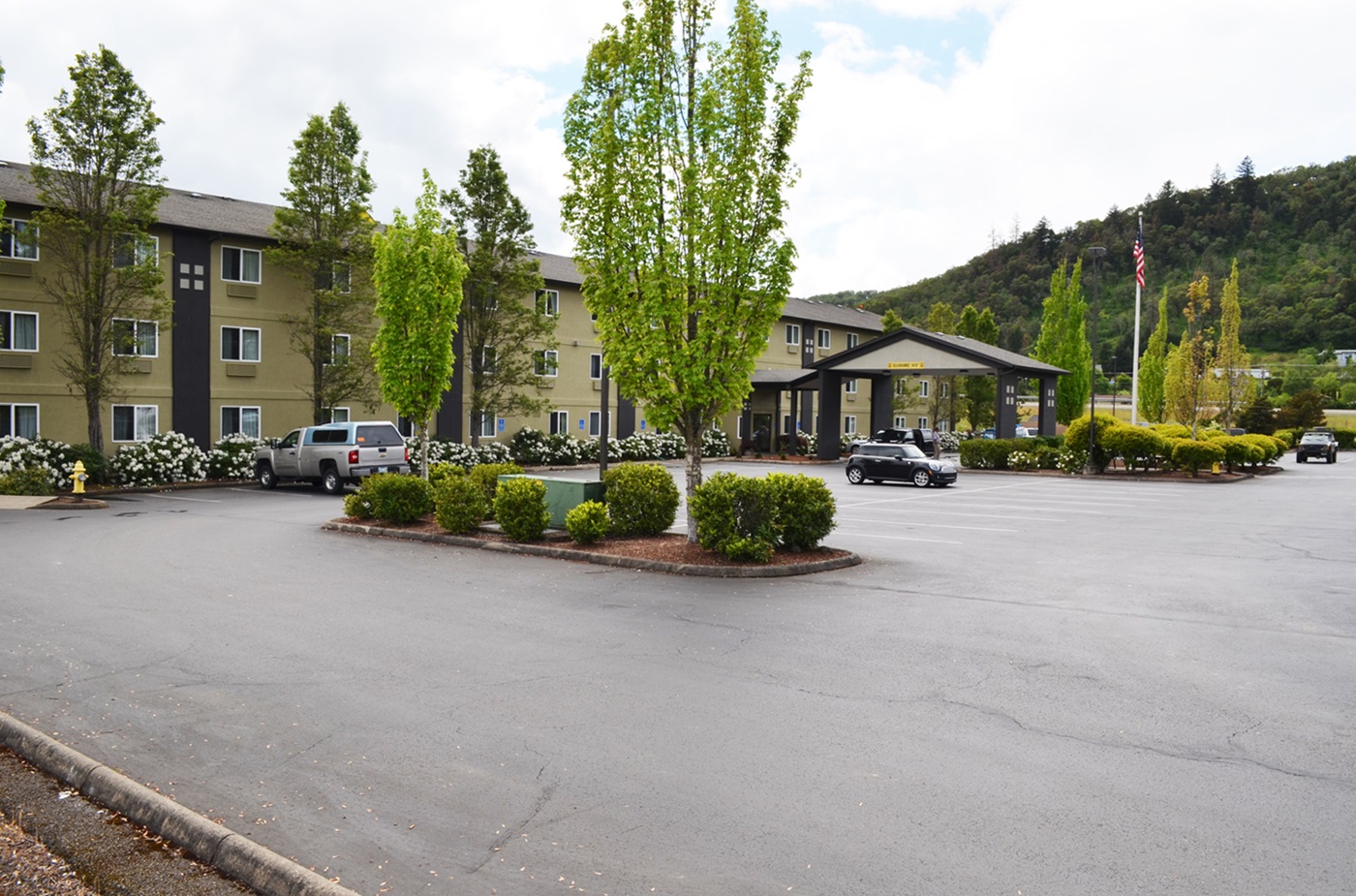 Front of hotel with parking lot and trees