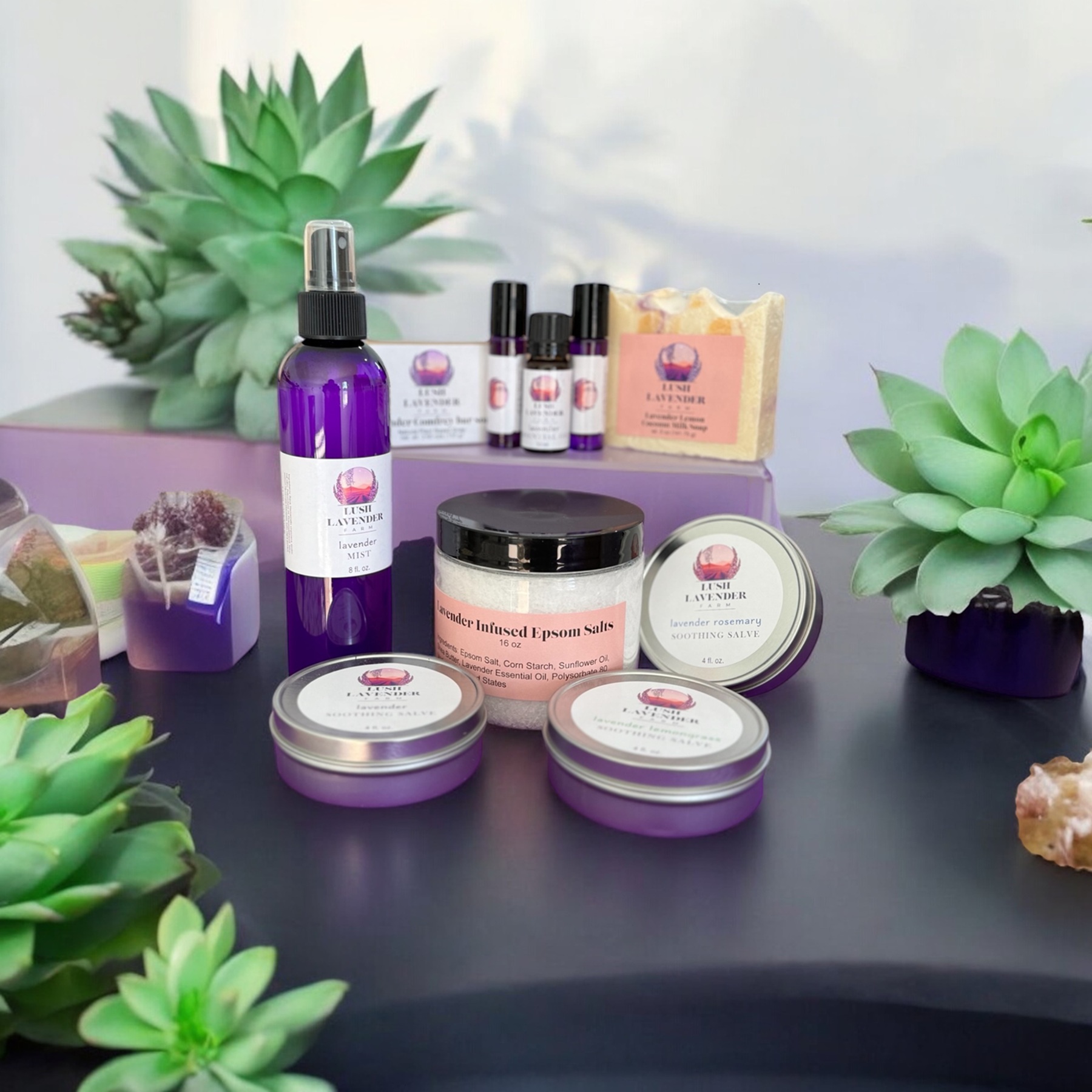 Assortment of Lush Lavender products on table with green succulents