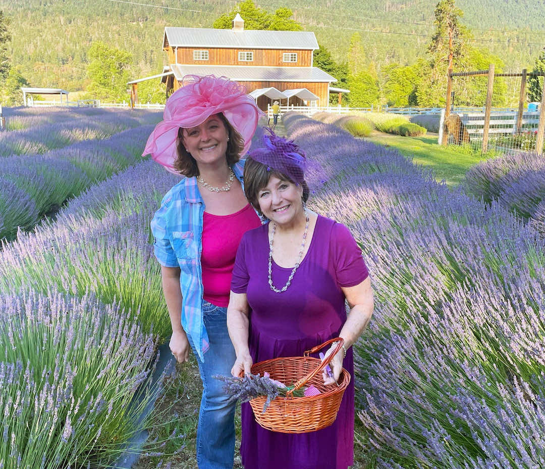 Two Applegate River Lavender staff standing before a field of lavender