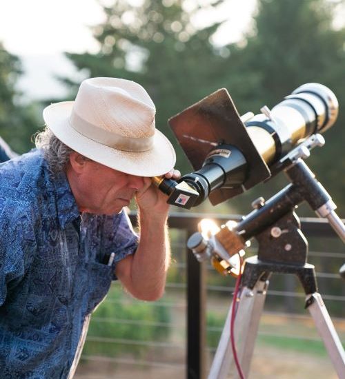 man looking through telescope
