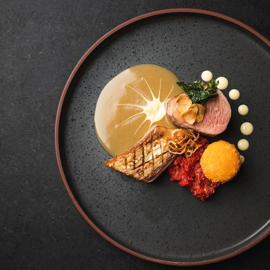 close up of fine dining dish on black plate