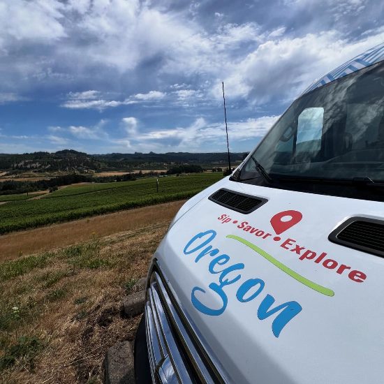 Sip Savor Explore tour van with blue skies and rolling hills scenery in background