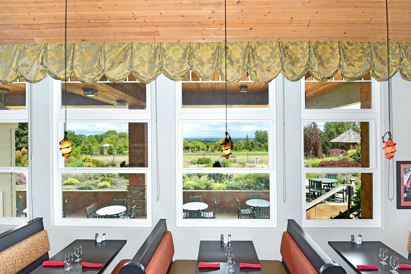 interior of restaurant booths and windows overlooking beautiful green gardens