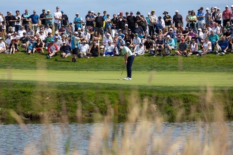 golfer on a golf course with a crowd watches