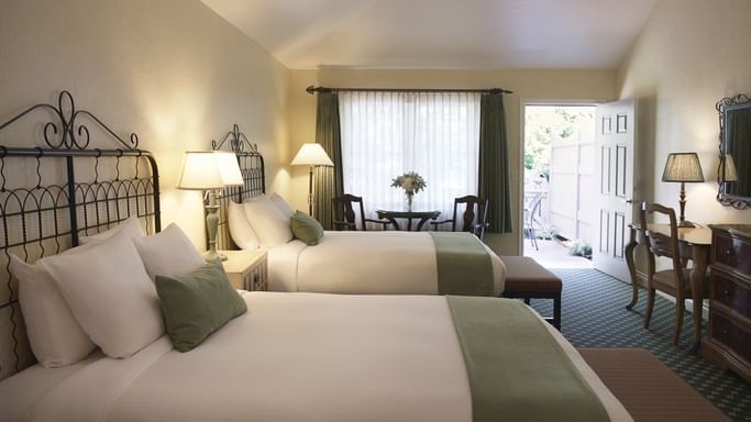 interior of hotel room with two beds with white linens