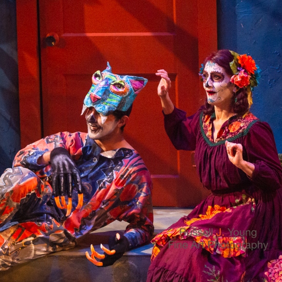 two people in costume and masks on stage