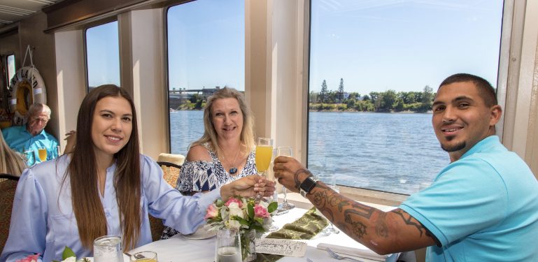 three people cheers while having brunch on Portland Spirit cruise