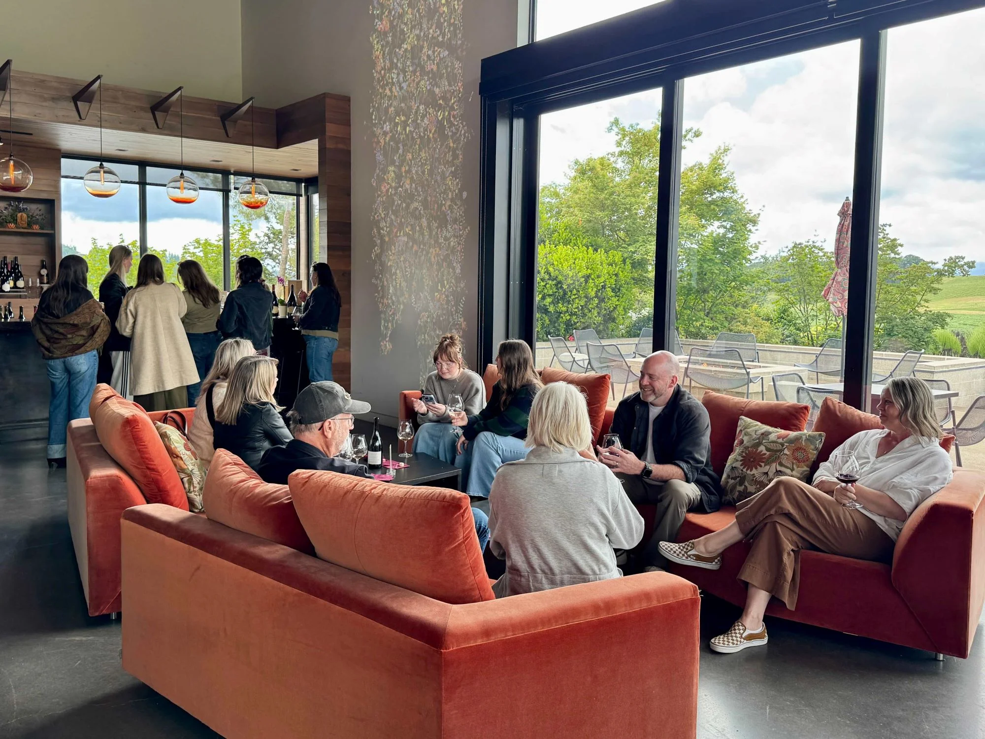 interior of wine tasting room with orange comfy couches and people drinking wine