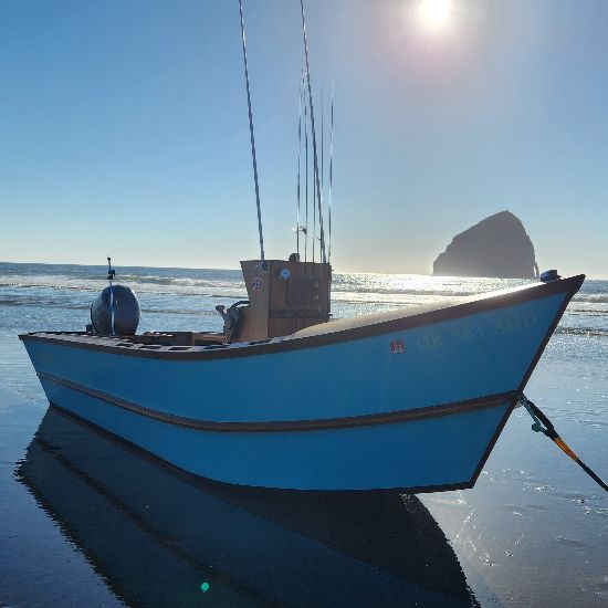 fishing boat on the sand with ocean in background