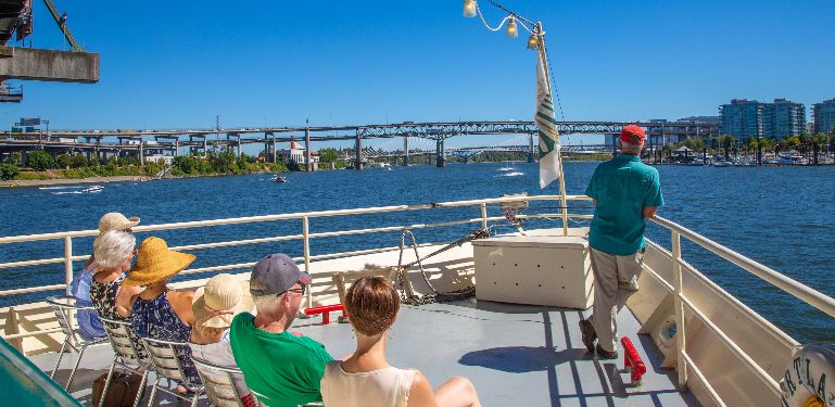 people sitting on deck sightseeing on the Portland Spirit