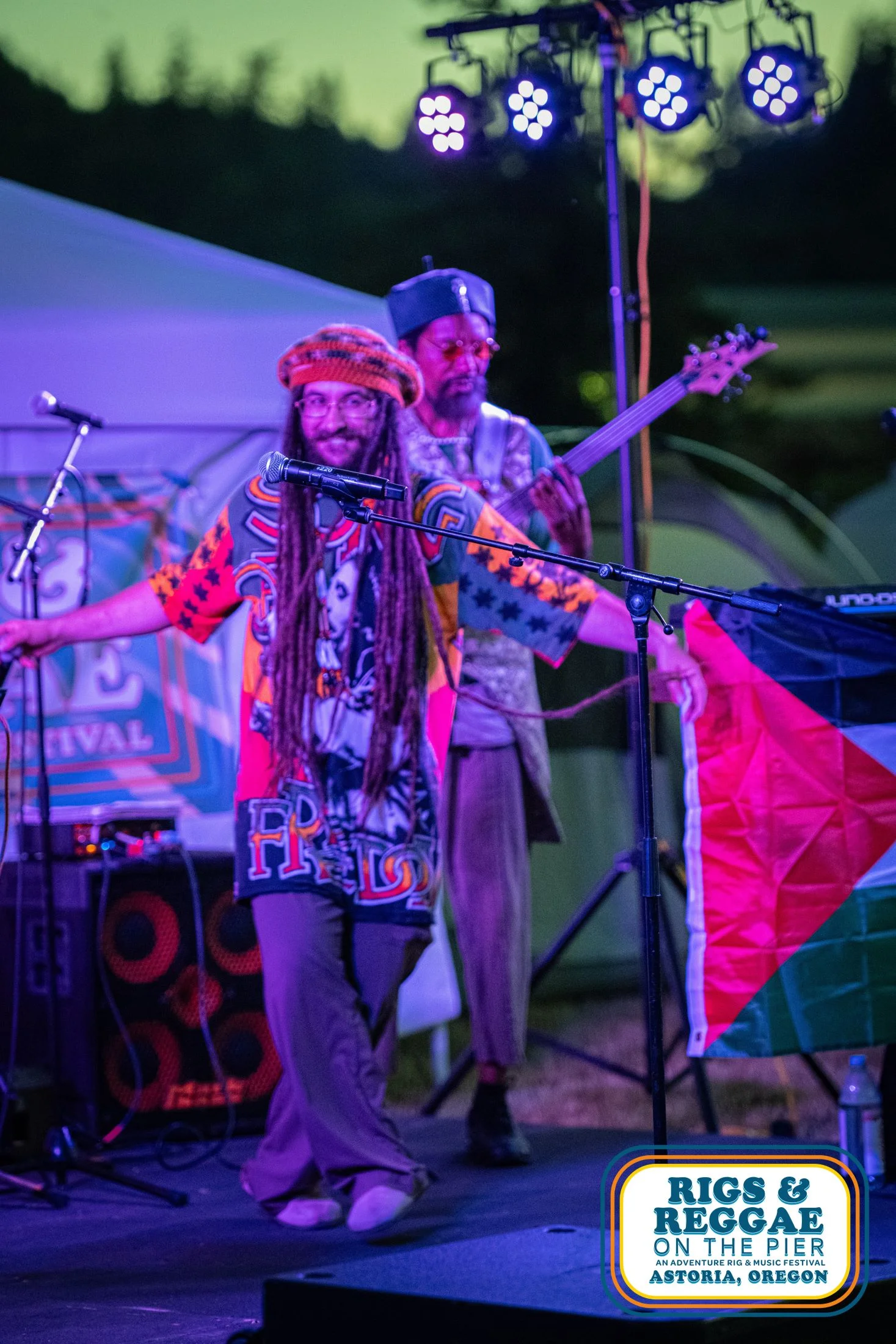 Two Reggae artisit in colorful clothes perform on outdoor stage