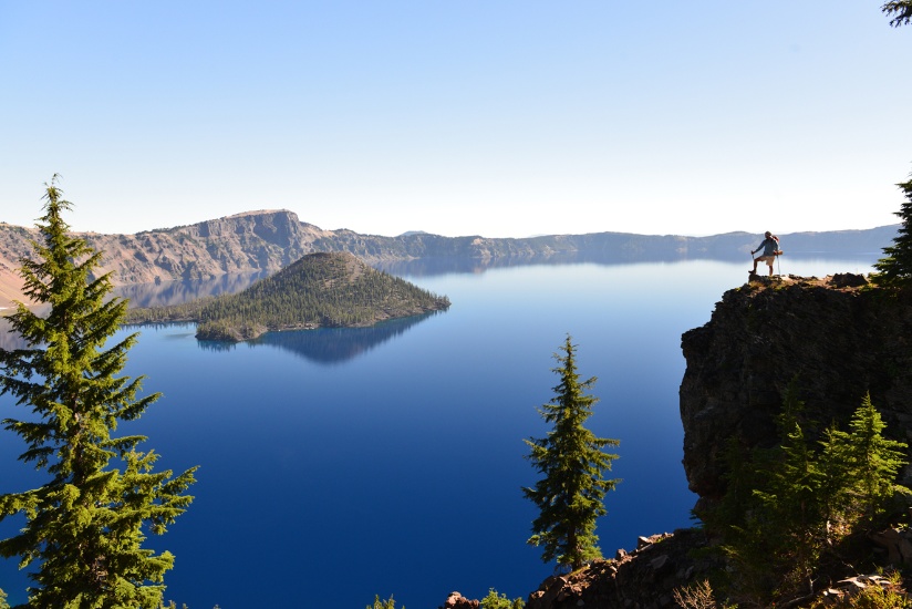 Crater Lake with hiker on high rock face