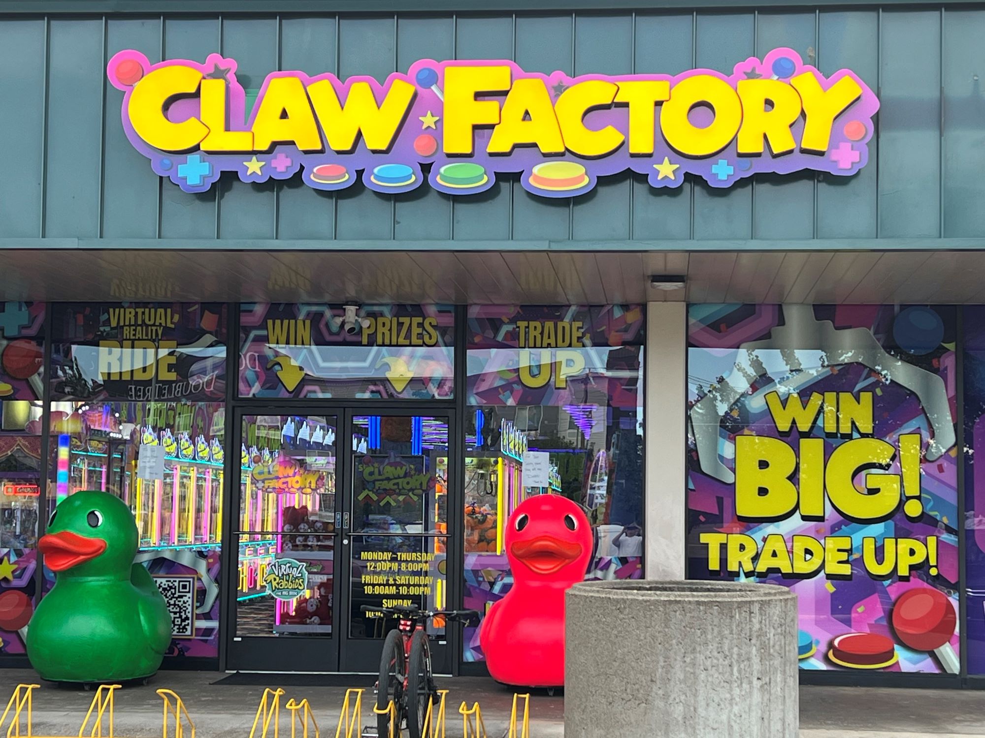 Exterior of the Claw Factory arcade store with two large red and green rubber duckies
