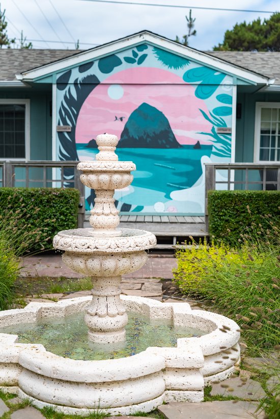exterior of Inn with colorful mural and decorative water fountain