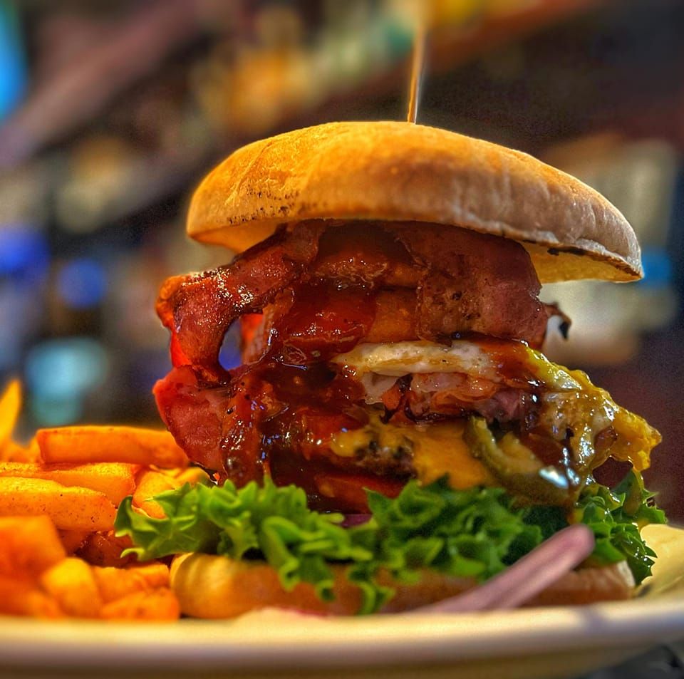 bacon cheeseburger with fried egg and sauce on a bun