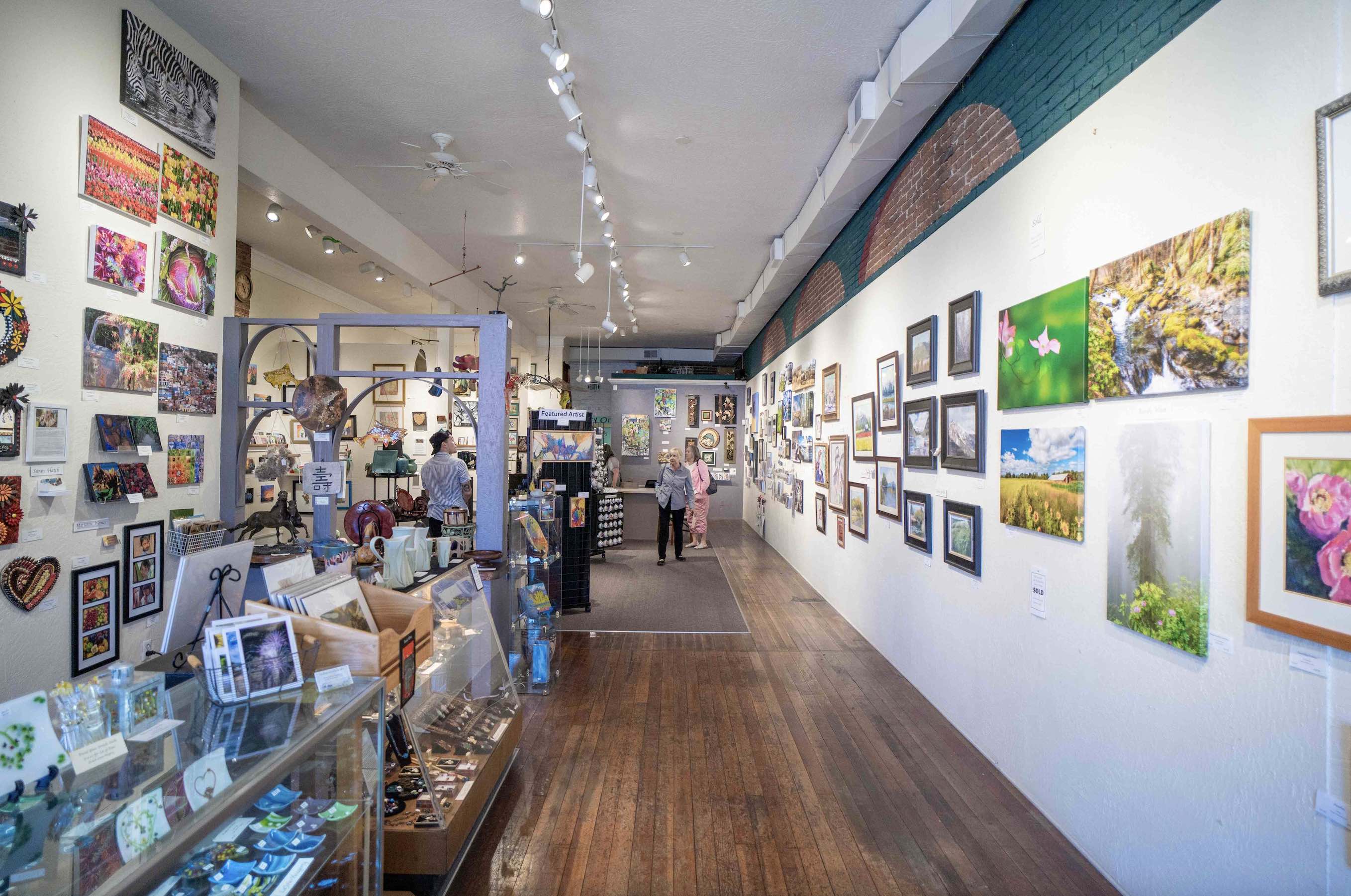 Grants Pass Museum of Art, Gallery One shop, full of vibrant art covering the walls.