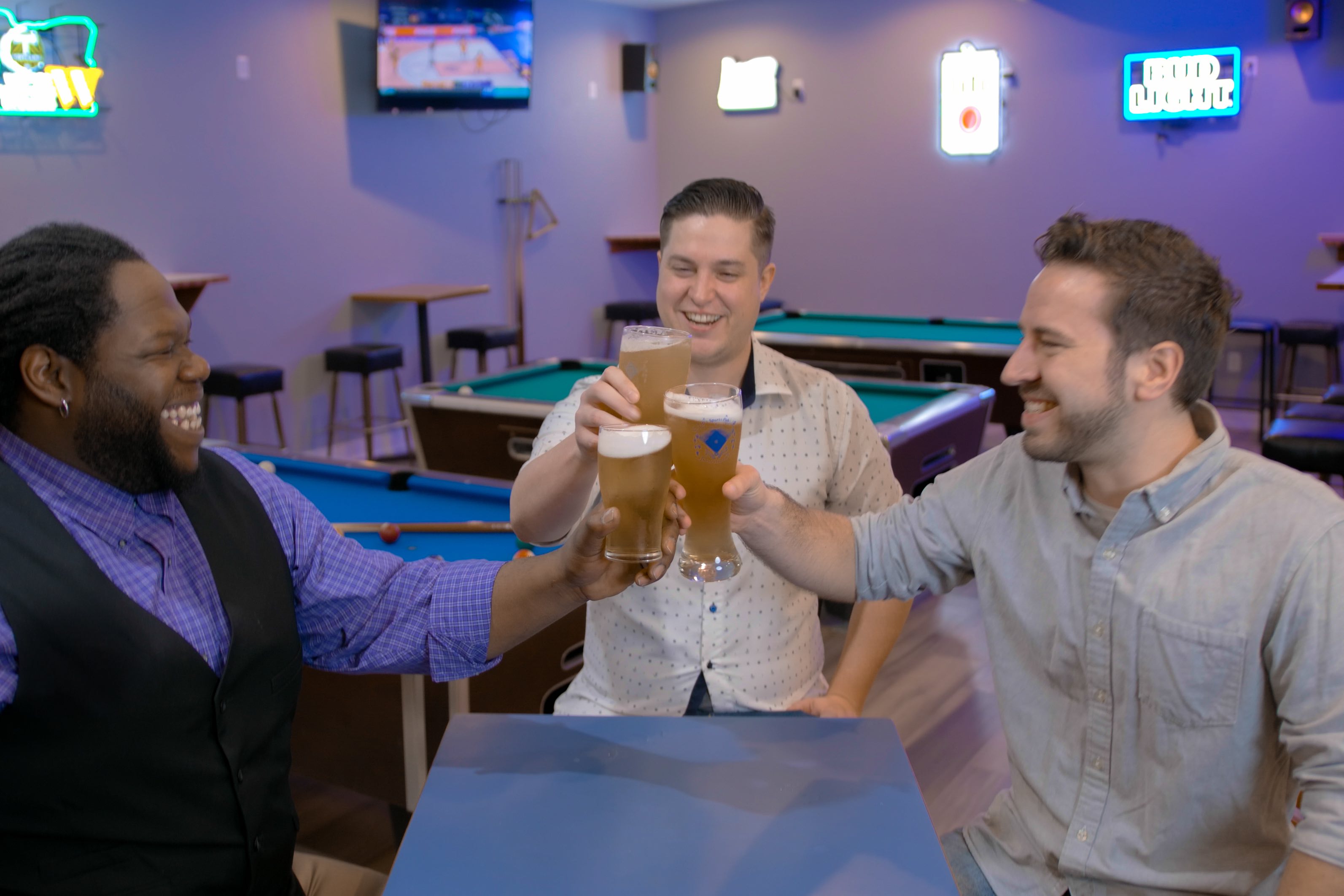 Wildriver Brewing, group cheers with neon beer signs in the background