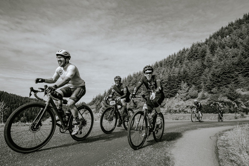 Cyclists smile at the camera during the West Coast Gravel event