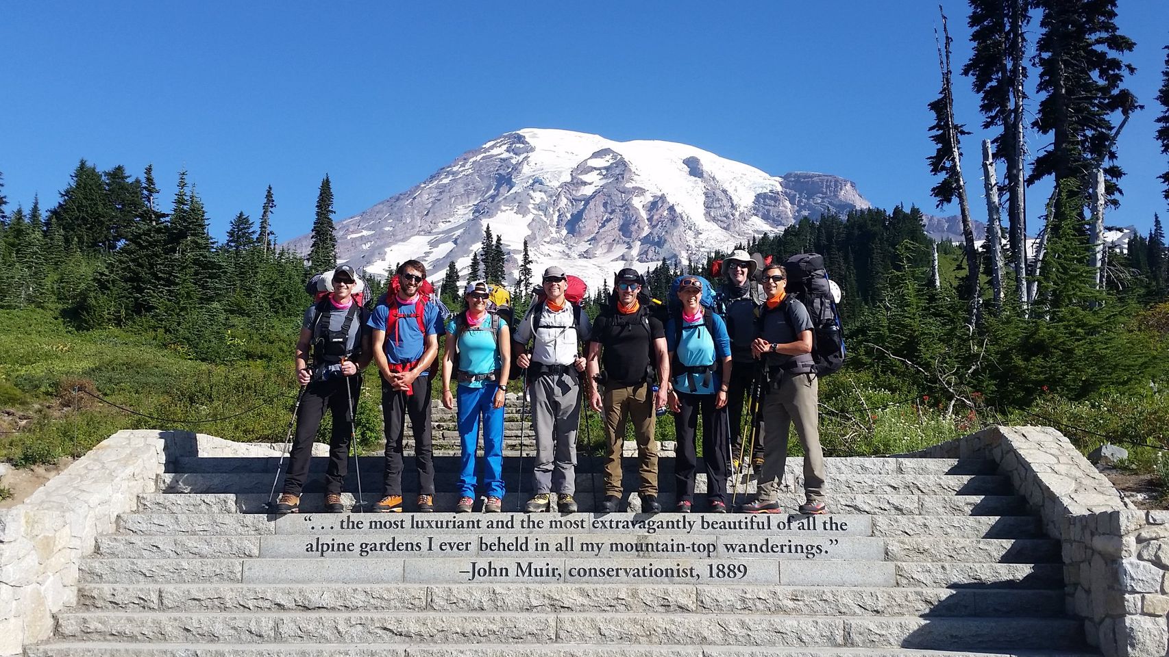 Group of mountaineers stanind in front of a snow capped mountain