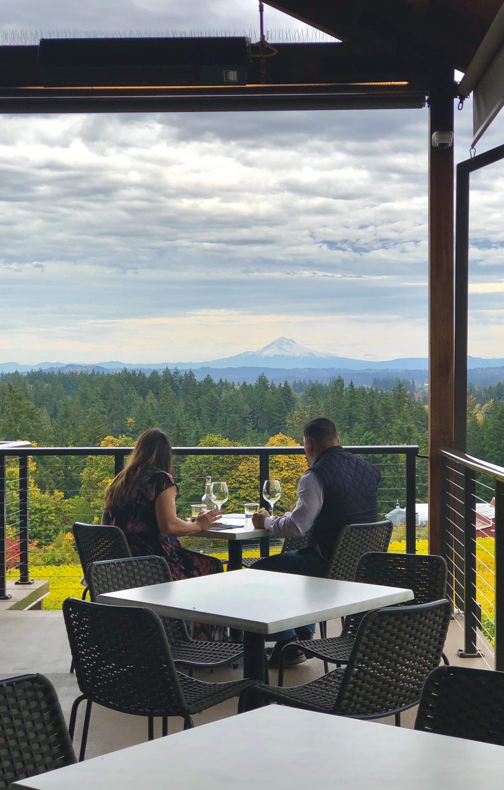 A couple sitting at an outside table looking at the view