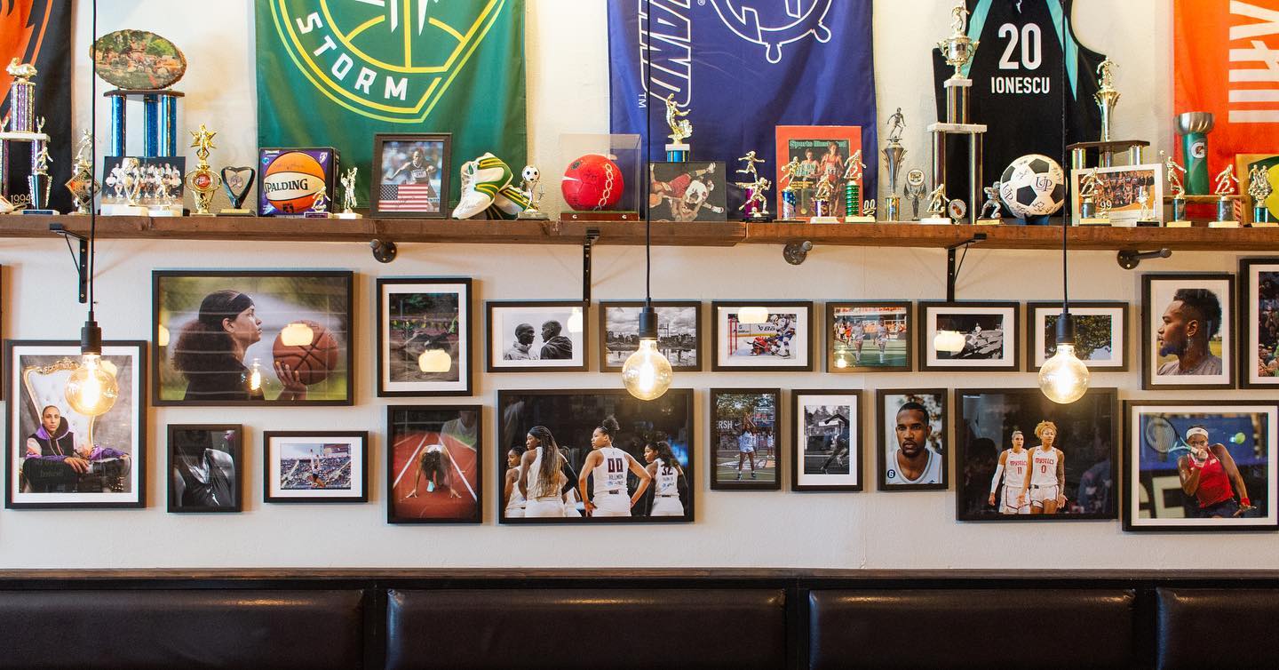 Bar wall showcases athlete images, trophies and team flags