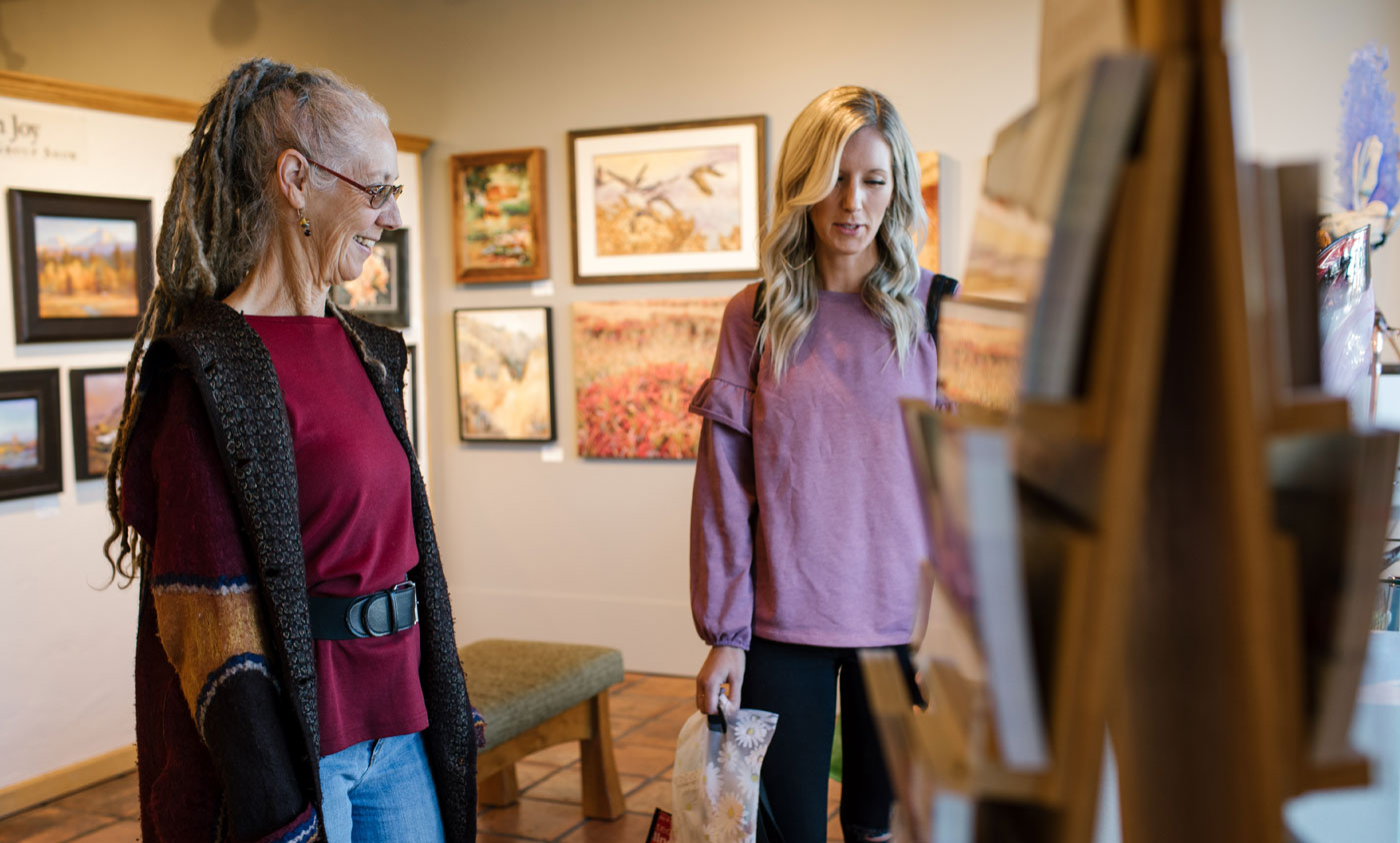 two people talking at an art exhibit
