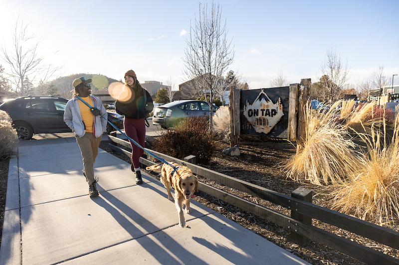 couple with dog walking into On Tap