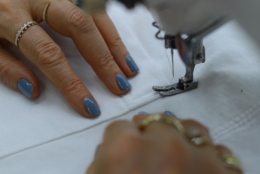hands sewing on a sewing machine