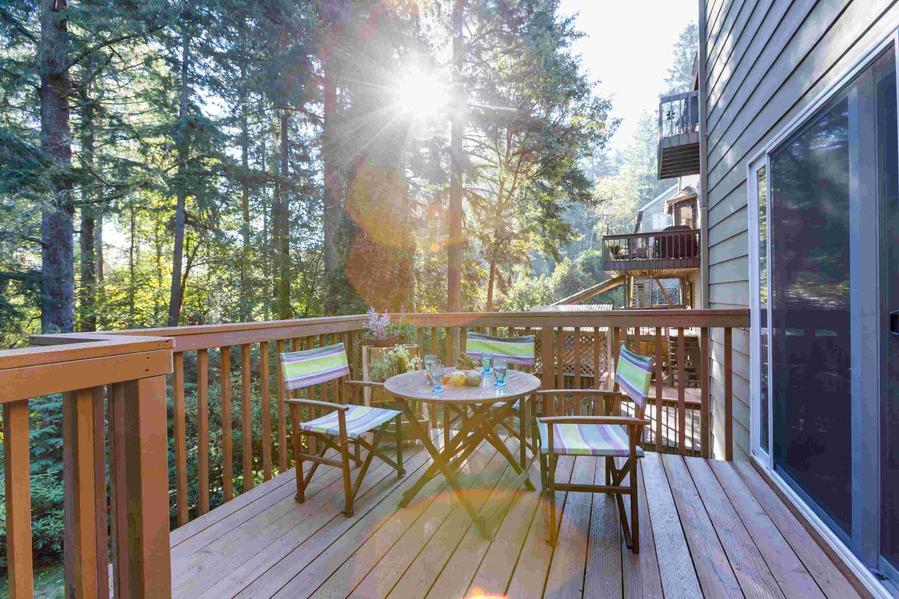 Two chairs sit at a small round table on the cedar deck at Oregon Jade Lodging.