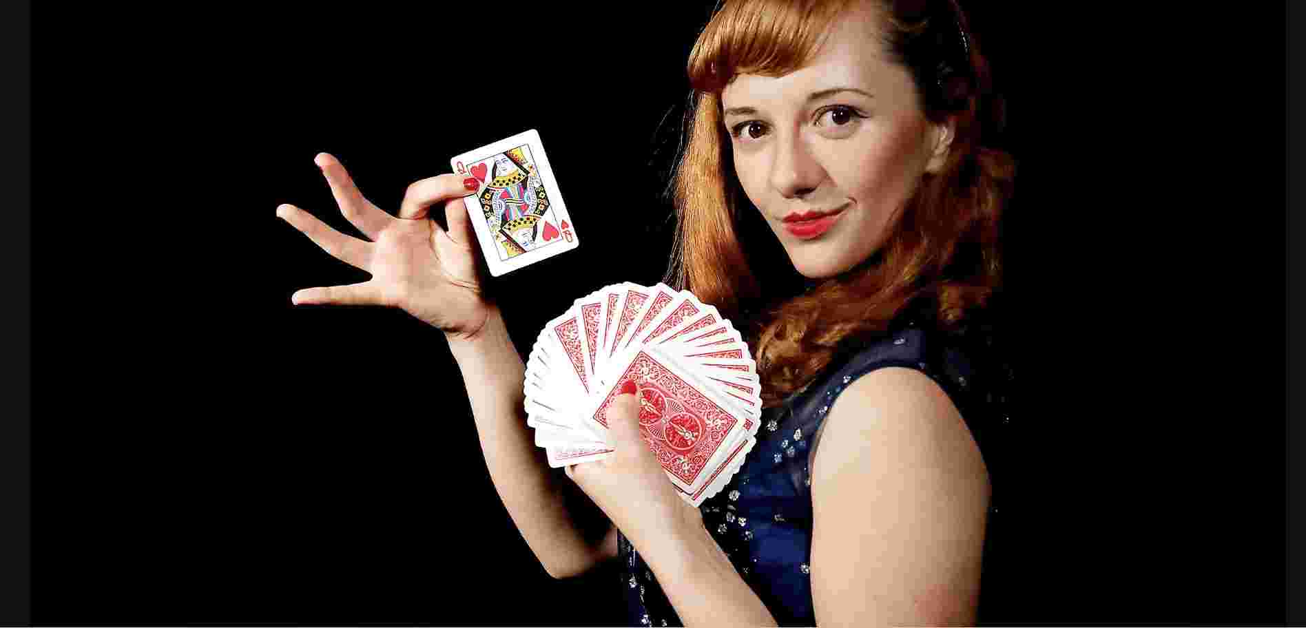 Magician holds up a queen of hearts