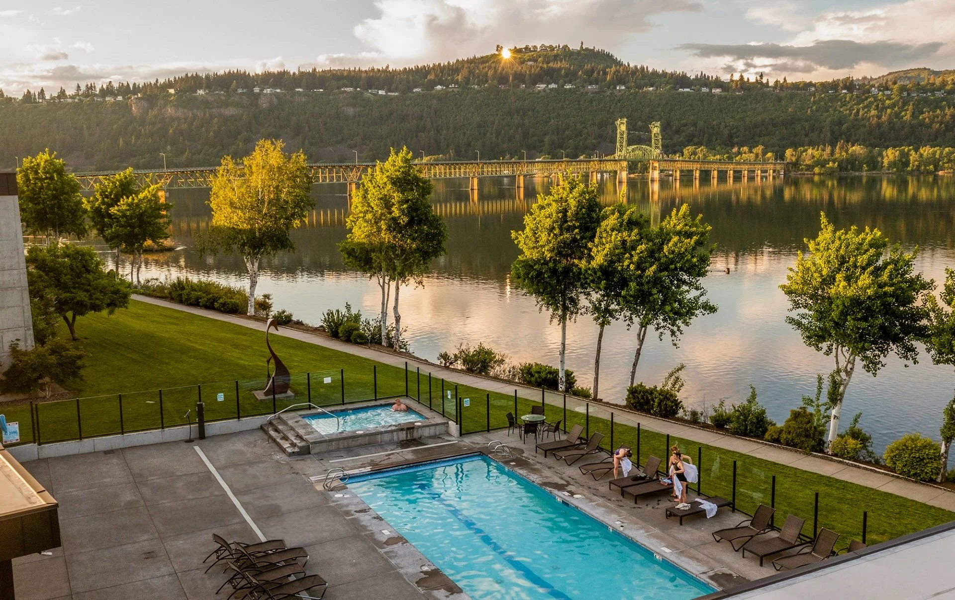 A turquoise swimming pool looks out over the Columbia River and the Hood River–White Salmon Interstate Bridge.