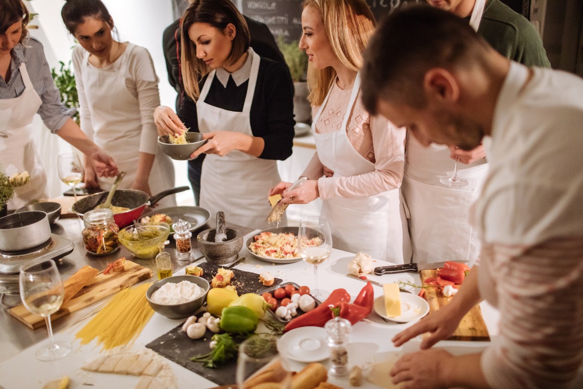 Group wearing white aprons attending a cooking class