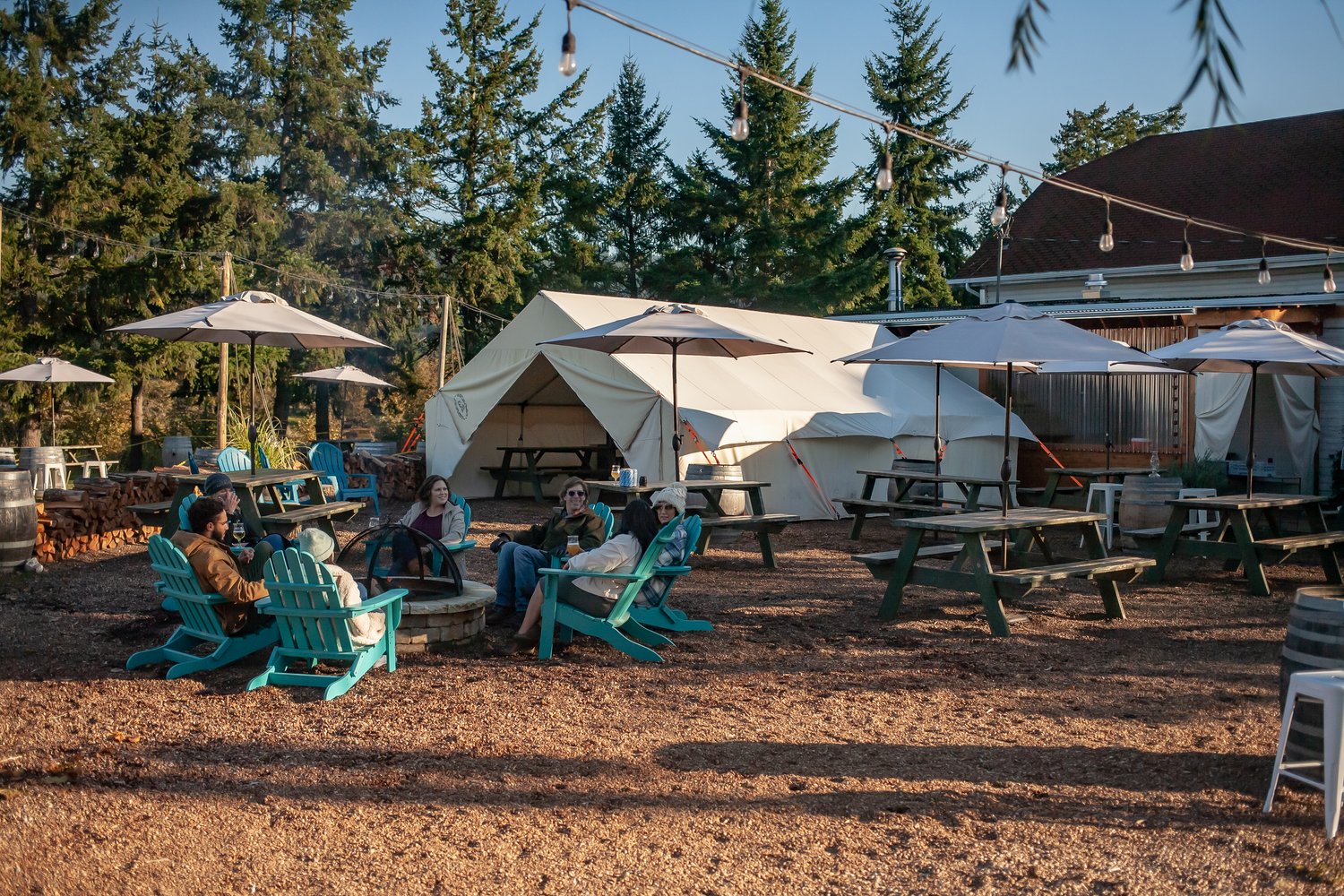 people sitting at a campfire in front of a tent