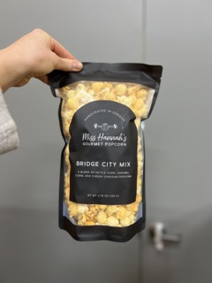 person holding up a bag of popcorn