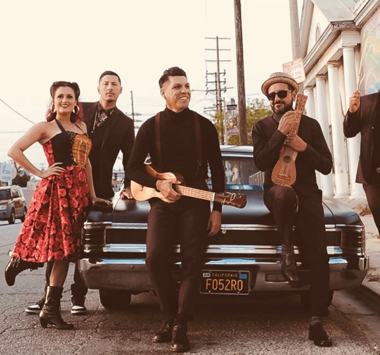 Musicians standing outside leaning on a car