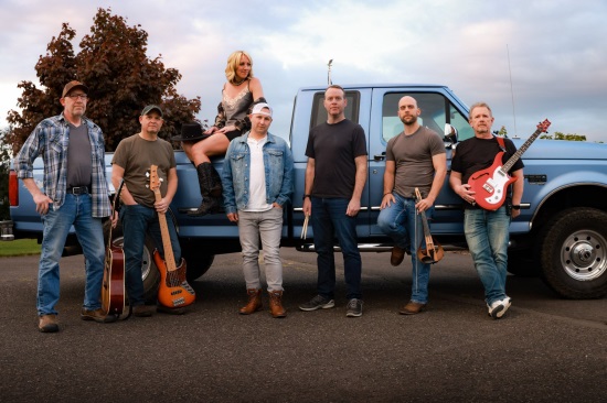 7 people standing outside in front of a pickup truck