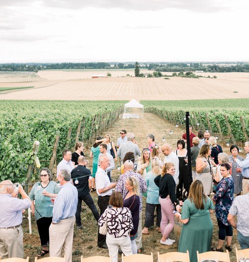 A group of people enjoying the outdoor vineyard venue