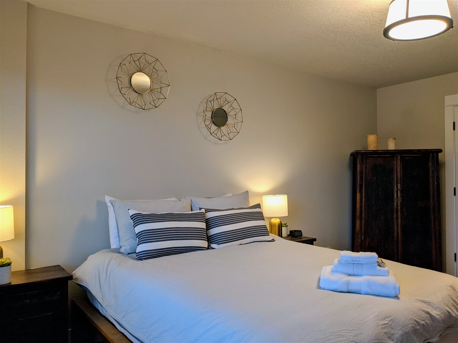 Small view of bedroom, including bed, side table, and chest