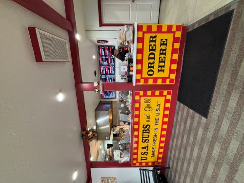 Carpet leads to a red service counter. A striped sign posted says "ORDER HERE"